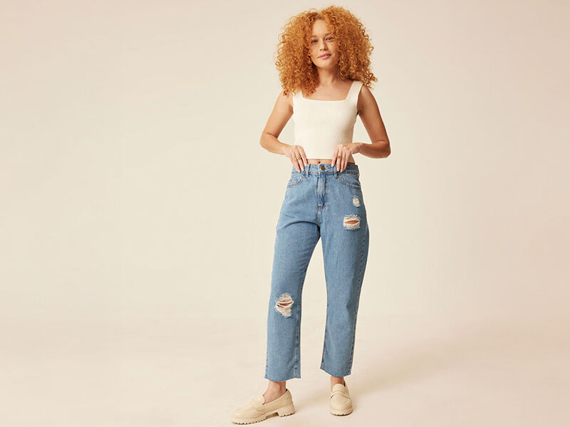 Modelo com calça jeans rasgada e blusa branca