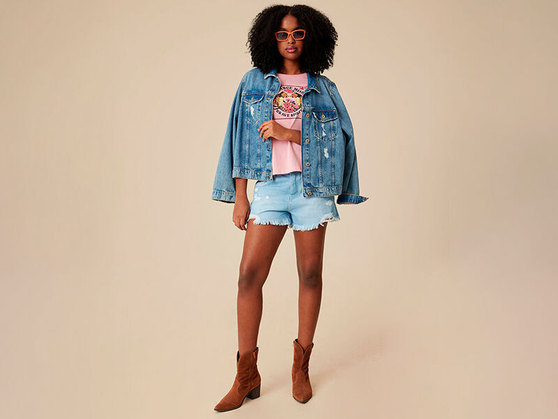 Modelo vestindo jaqueta jeans e short curto