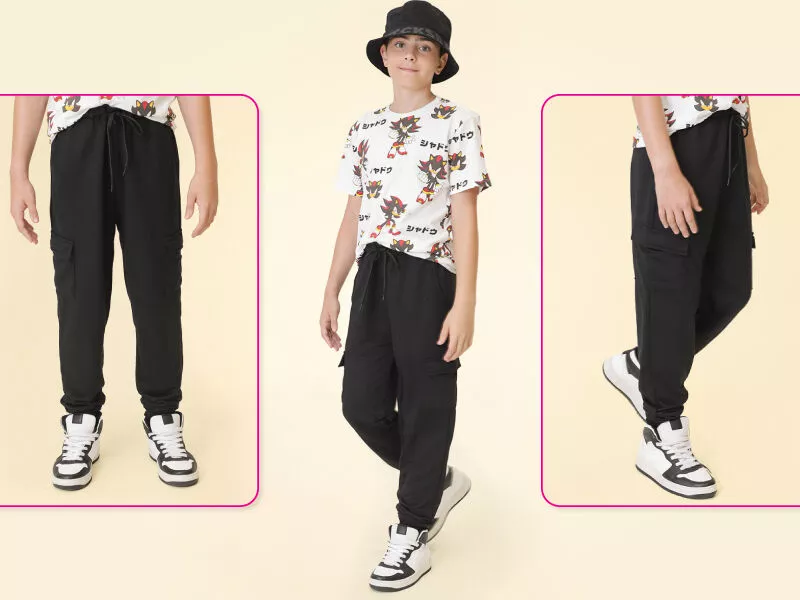 Criança usando calça preta e camiseta estilosa.