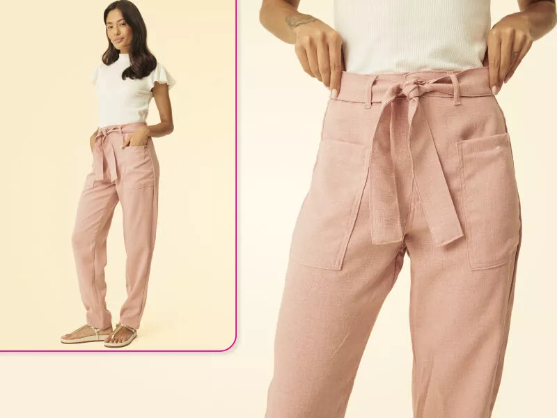 Mulher usando calça rosa com laço na cintura.