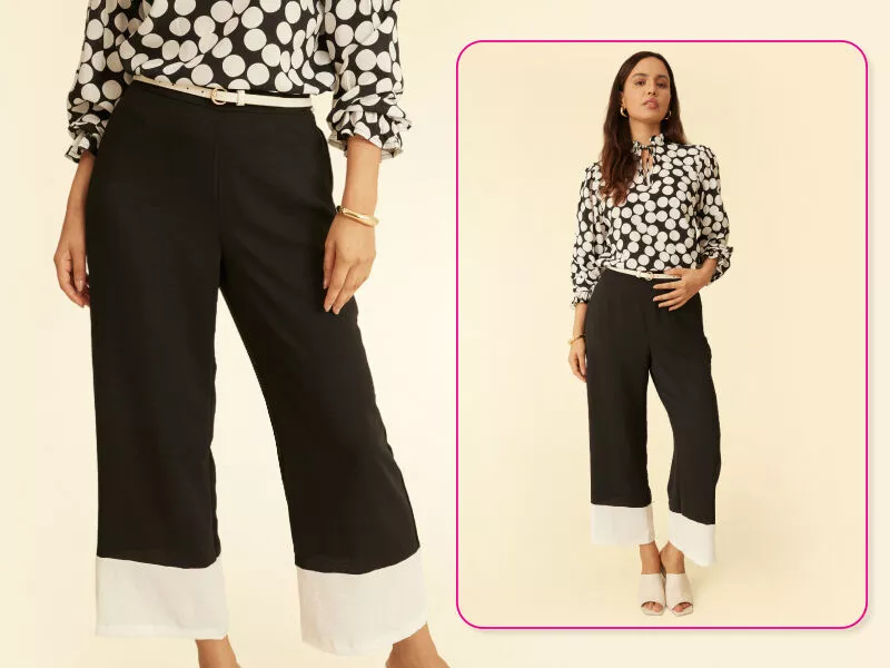 Mulher usando camisa de bolinhas e calças com detalhes brancos.