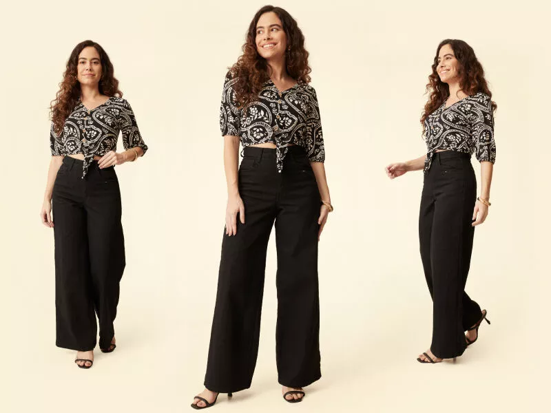 Mulher sorridente usando blusa estampada e calça preta