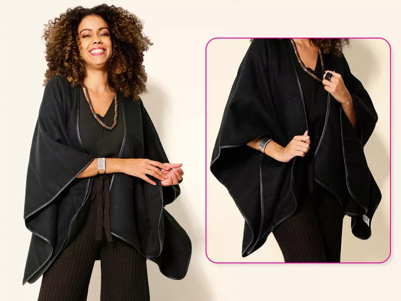 Mulher sorrindo usando poncho preto elegante