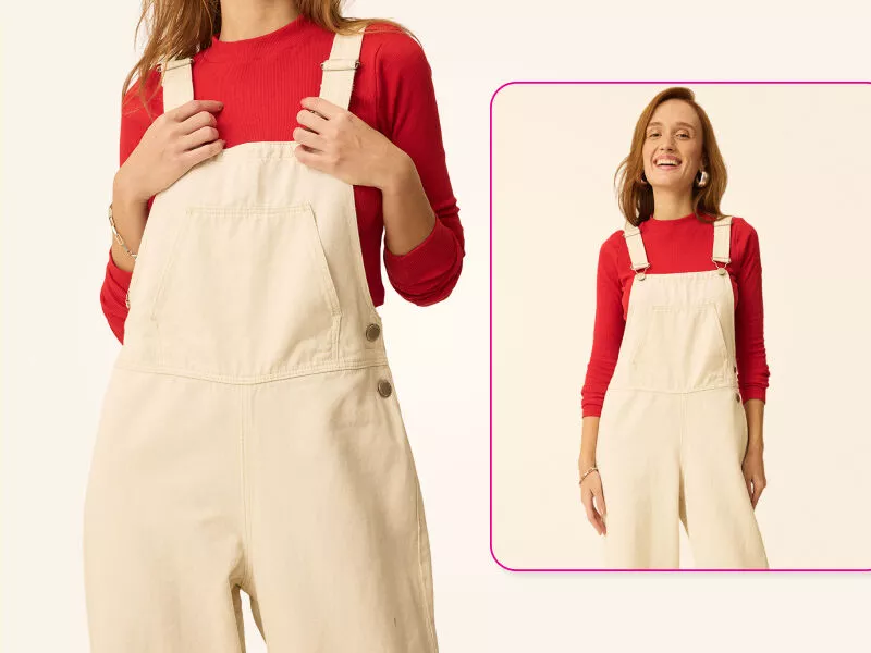 Mulher sorrindo com macacão claro e blusa vermelha.