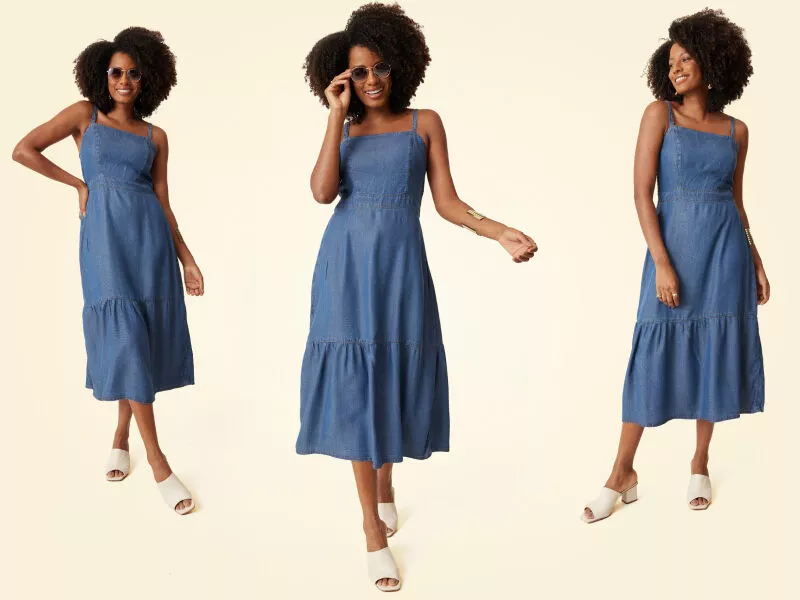 Vestido jeans com babado e óculos escuros em fundo neutro