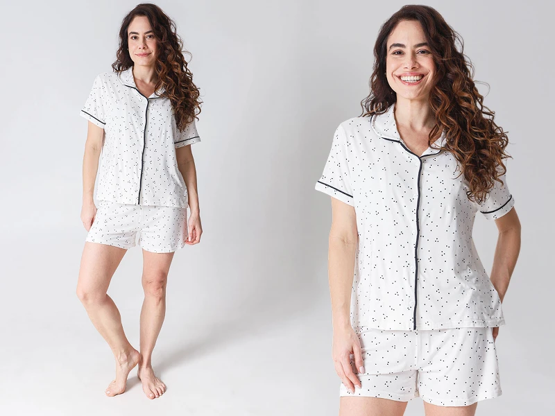 Pijama branco às bolinhas pretas, com camisa de manga curta e shorts.