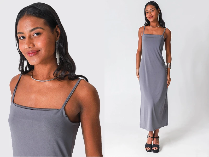 Mulher a usar vestido comprido cinzento de alças finas, acessórios prateados e sandálias pretas.