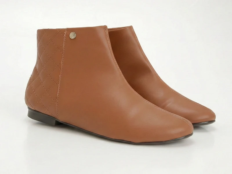 Botins castanhos de senhora com detalhe acolchoado no calcanhar e sola rasa. Calçado de cano curto elegante.