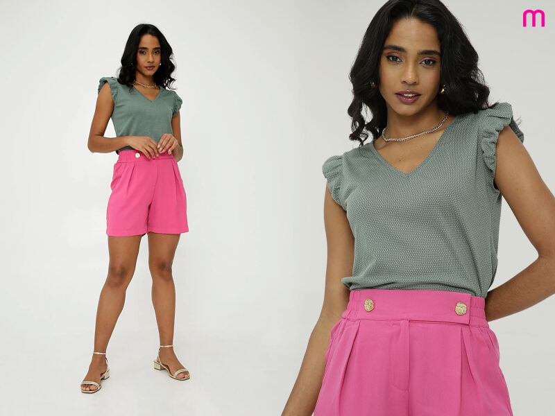 Modelo vestindo blusa verde e shorts rosa