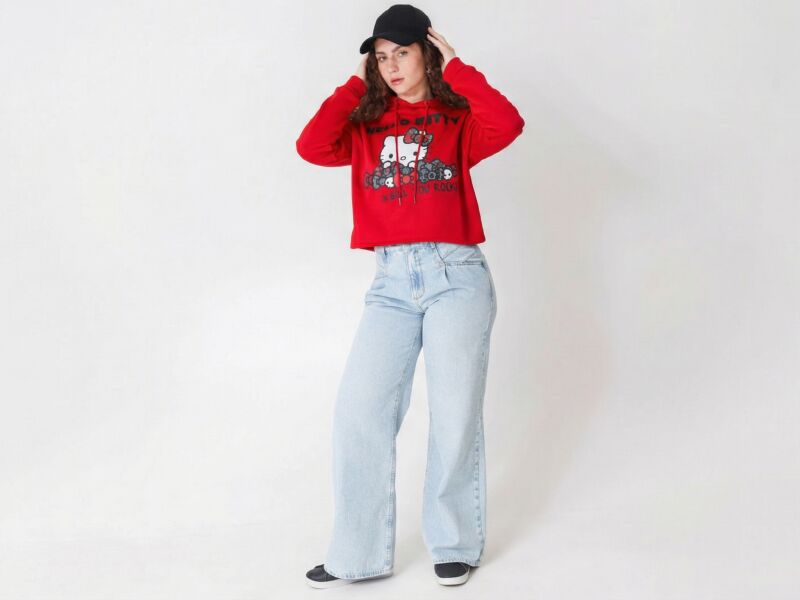 Jovem com moletom vermelho e jeans claro em pose estilosa