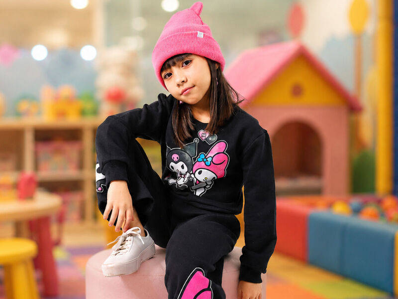 Menina com boné rosa em ambiente recreativo colorido