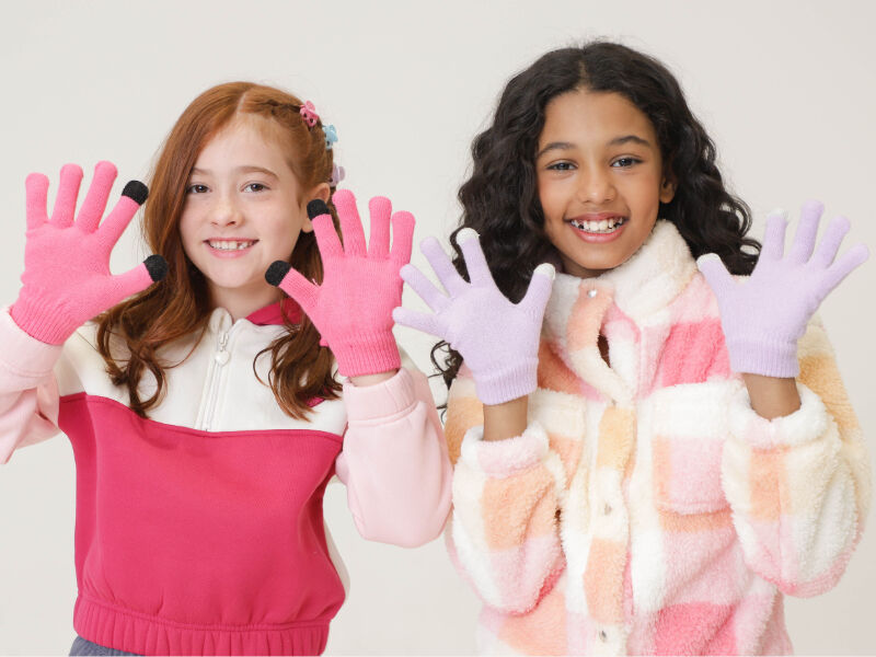 INFANTIS10 Duas meninas sorrindo com luvas coloridas.