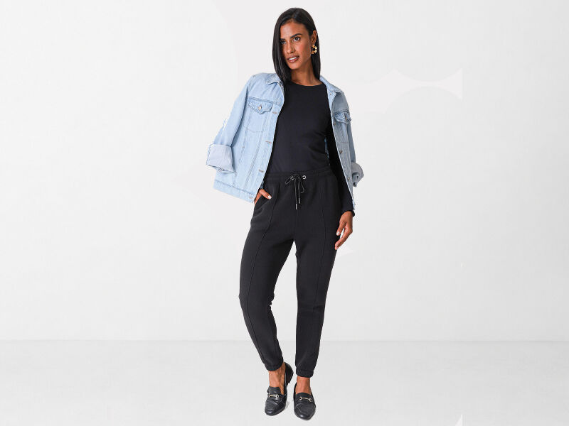 ATLEISURE 3 Mulher vestindo macacão preto com jaqueta jeans