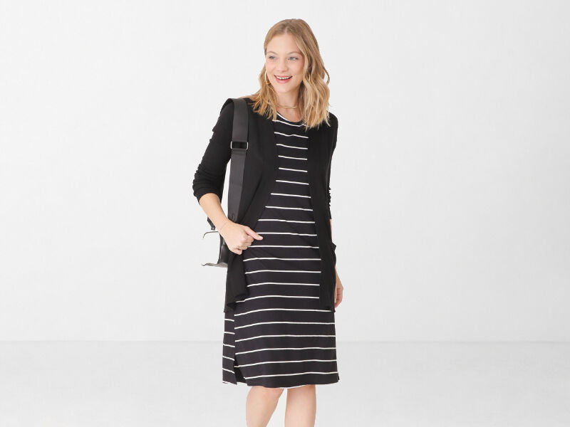 allblack 5 Mulher sorrindo com vestido listrado e casaco preto