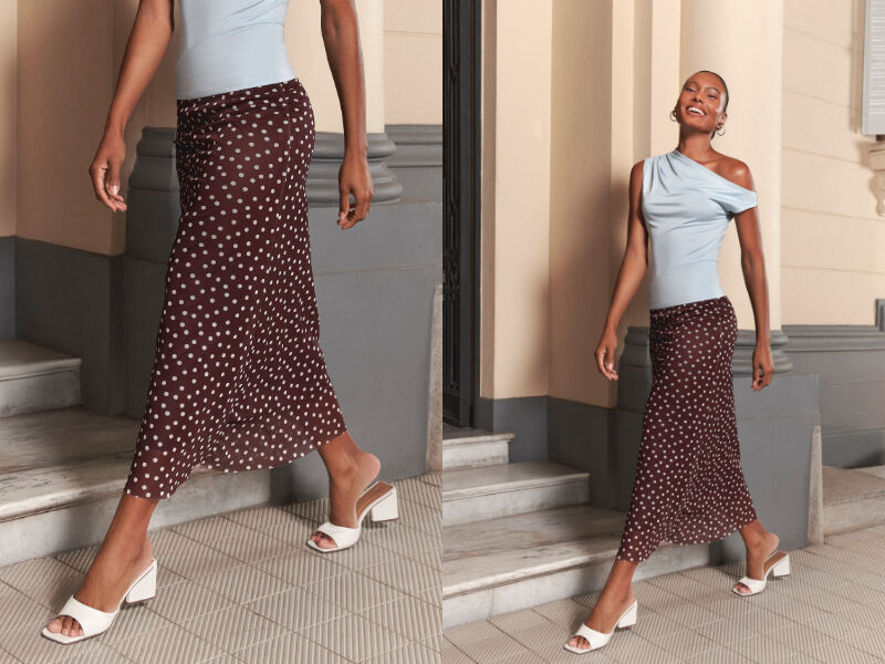 Mulher elegante caminhando com saia de bolinhas.