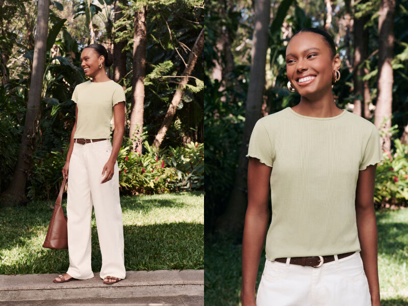 Mulher sorrindo em ambiente natural, vestindo blusa verde.